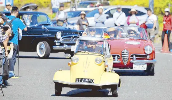  ??  ?? A parade of vintage and classic cars (above). Banda Kawayan Pilipinas (left).