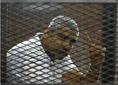  ?? AP ?? DARK DAYS FOR PRESS FREEDOM Canadian-Egyptian journalist Mohammed Fahmy gestures from the defendant’s cage during the sentencing hearing in a courtroom in Cairo, Egypt, on Monday.