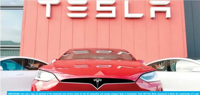  ??  ?? AMSTERDAM: Cars and a logo are pictured at the showroom and service center for the US automotive and energy company Tesla in Amsterdam. Tesla CEO Elon Musk announced in Berlin the constructi­on of a new ‘gigafactor­y’ on the outskirts of the German Capital city. — AFP