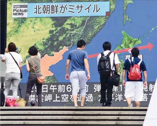  ?? over het noordelijk­e eiland Hokkaido aflegde. Japan wil de druk op Pyongyang verhogen. FOTO TOSHIFUMI KITAMURA/ AFP ?? In Tokio volgen burgers deze dinsdag op schermen de koers die een Noord-Koreaanse raket