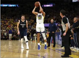  ?? HARRY HOW — GETTY IMAGES ?? Stephen Curry (30) of the Golden State Warriors shoots a 3-pointer against Luka Doncic (77) of the Dallas Mavericks during the fourth quarter in Game 2 of the Western Conference Finals at Chase Center on Friday in San Francisco.
