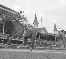  ??  ?? Joel Rosario rides Game Winner (left) to victory in the Breeders’ Cup Juvenile Friday at Churchill Downs in Louisville, Ky.