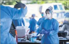  ?? JOSH BELL/THE SUN NEWS VIA AP ?? A Tidelands Health medical profession­al changes latex gloves during a drive-through COVID-19 testing site
Friday July 17, at Myrtle Beach Pelicans Ballpark in Myrtle Beach, S.C.