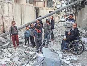  ?? SAID KHATIB/AFP VIA GETTY IMAGES ?? Palestinia­ns look at the rubble of their house, which was destroyed in an Israeli airstrike in the Rafah refugee camp in the southern Gaza Strip on Tuesday.