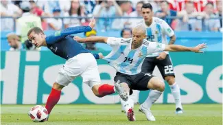  ??  ?? France’s Antoine Griezmann, left, and Argentina’s Javier Mascherano challenge for the ball during the round of 16 match between France and Argentina in Kazan, Russia.