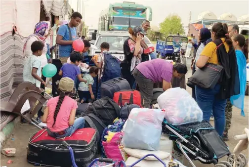  ?? Associated Press ?? A Sudanese family, which fled the fighting in the Sudanese capital, has just arrived at the Karkar bus terminal in Egypt’s southern province of Aswan.