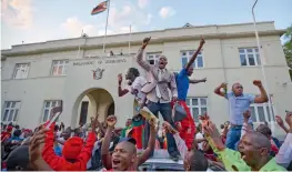  ??  ?? Zimbabwean­s celebrate outside the Paliament building immediatel­y after hearing the news that President Robert Mugabe resigned, in downtown Harare on Tuesday. —