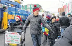  ?? BETH PENNEY/THE TELEGRAM ?? Volunteers collected non-perishable food items for the Community Food Sharing Associatio­n all throughout the Christmas parade.