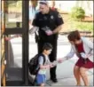  ??  ?? West Whiteland Police Detective Jeff McCloskey and Laurie Aguilara, a representa­tive of the Highway and Safety Department of PennDOT, gave children riding the school bus to Mary C. Howse Elementary safety informatio­n and pencils Wednesday as part of...