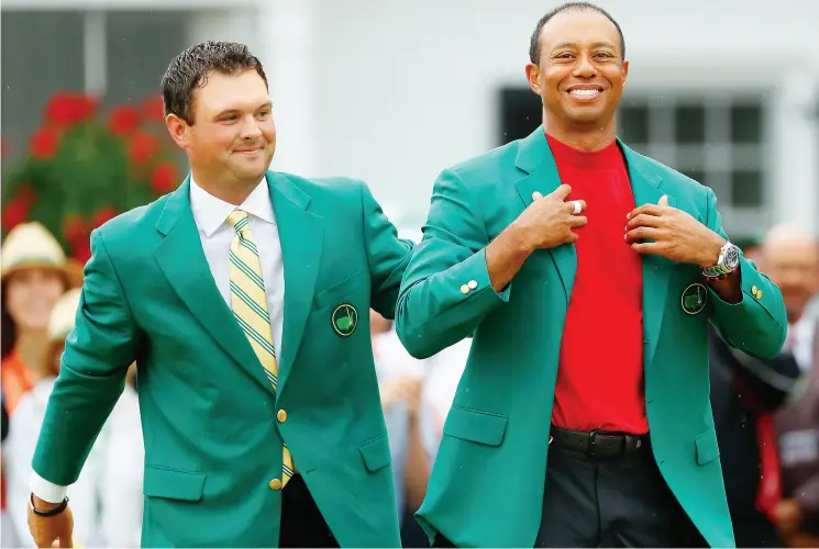  ?? KEVIN C. COX / GETTY IMAGES ?? Tiger Woods, right, is awarded the green jacket by last year’s Masters champion Patrick Reed after winning the Masters at Augusta National Golf Club on Sunday.