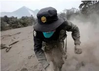  ?? Reuters ?? A police officer stumbles while running away after the Fuego volcano spewed more ash in Guatemala. —