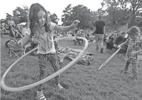  ?? NIKKI BOERTMAN/THE COMMERCIAL APPEAL ?? Kelsi Cowles, 6, practices her hula hoop skills with her sister Edi Cowles, 4, to the sounds of the music from the Jim Dickinson Folk Festival on Sept. 19, 2011, at the Levitt Shell.