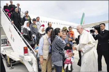  ?? FILIPPO MONTEFORTE / ASSOCIATED PRESS ?? Pope Francis greets a group of Syrian refugees upon their landing at Rome’s Ciampino airport Saturday. He brought home 12 Syrian Muslims aboard his charter plane after an emotional visit to the hard-hit Greek island of Lesbos.