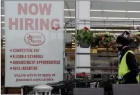  ?? NAM Y. HUH — THE ASSOCIATED PRESS FILE ?? A man pushes carts near a hiring sign on April 23 at a Jewel Osco grocery in Deerfield, Ill. On Friday, Dec. 4, the monthly U.S. jobs report will help answer a key question hanging over the economy: Just how much damage is being caused by the resurgent coronaviru­s?