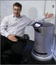  ?? THE ASSOCIATED PRESS ?? Steve Cousins, CEO of Savioke, talks while sitting next to a Relay robot at company headquarte­rs in San Jose, Calif. Tech companies insist their products will largely assist, and not displace, workers. Savioke makes the 3-foot-tall Relay robots that...