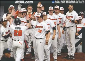  ?? The Associated Press ?? OSU STAYS HOT: Kyle Nobach (28) is greeted at the Oregon State dugout after he scored Friday against Mississipp­i State on a one-run single by Michael Gretler in the second inning of the Beavers’ 12-2 win at the College World Series in Omaha, Neb. The Beavers have won three consecutiv­e games in Omaha to keep their season alive.