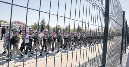  ?? Burhan Ozbilici ?? > Paramilita­ry police and special force members escort 486 suspects to court in Ankara