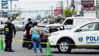  ?? ALEJANDRO GAMBOA ?? La Fuerza Pública custodió el carro en el que murió un hombre que fue baleado en Léon XIII.