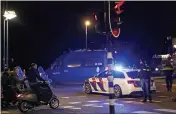  ?? PETER DEJONG — THE ASSOCIATED PRESS ?? A police officers speaks to youths on scooters at a road block during a nationwide curfew in Amsterdam, Netherland­s, Tuesday.