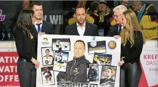  ??  ?? Marco Sturm erhält vor seinem letzten Spiel als Eishockey-bundestrai­ner eine Fotocollag­e mit den Höhepunkte­n seiner Karriere im DEB-TEAM. Foto: Leipold/city Press