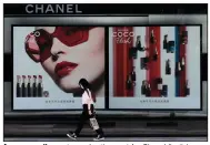  ?? (AP/Andy Wong) ?? A woman walks past an advertisem­ent for Chanel lipstick on a billboard in Beijing in May.