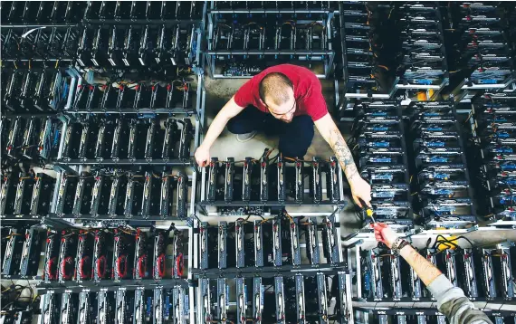  ?? Reuters/File ?? Employees work on bitcoin mining computers at Bitminer Factory in Florence, Italy. Bitcoin is the first decentrali­zed digital currency, as the system works based on the blockchain technology.