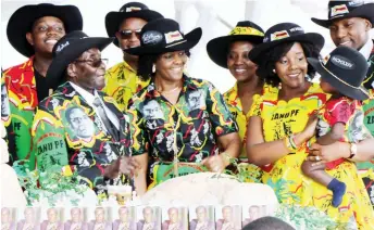  ??  ?? President Mugabe, First Lady Dr Grace Mugabe, with members of the First Family share a lighter moment as they prepare to cut the President’s birthday cake which was shaped like the Matobo Hills during celebratio­ns to mark his 93rd birthday in Matobo,...