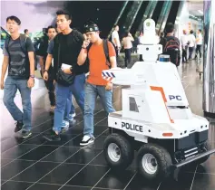  ?? — Reuters photo ?? A police surveillan­ce robot patrols the lobby of Suntec Convention Center during the Asean Summit in Singapore.