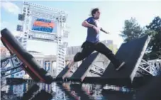  ?? AAron Ontiveroz, Denver Post file ?? Course tester Christian Greene runs over an obstacle before the 2013 “American Ninja Warrior Denver.”