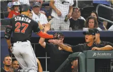  ?? John Bazemore / Associated Press ?? Miami’s Giancarlo Stanton is greeted by manager Don Mattingly last season. Mattingly will be back in 2018.