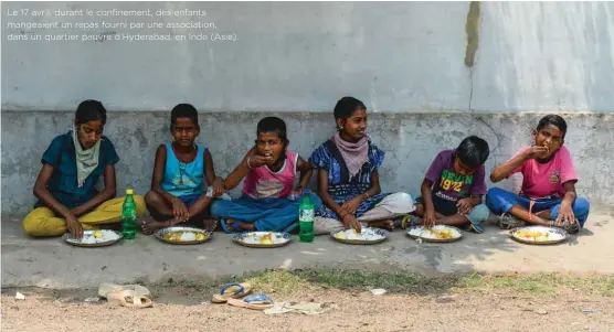  ??  ?? Le 17 avril, durant le confinemen­t, des enfants mangeaient un repas fourni par une associatio­n, dans un quartier pauvre d’Hyderabad, en Inde (Asie).