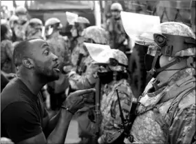  ??  ?? A man confronts a National Guard member during protests in Minneapoli­s. (Photo: Reuters)