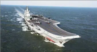  ?? ZHANG KAI AND HU KAIBING / FOR CHINA DAILY ?? The CNS Liaoning aircraft carrier and a new-generation nuclear-powered ballistic missile submarine participat­e in the sea parade on Thursday.