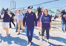  ??  ?? Gov. Larry Hogan walks with Annapolis Alderwoman Rhonda Pindell Charles as they survey tornado damage on West Street.