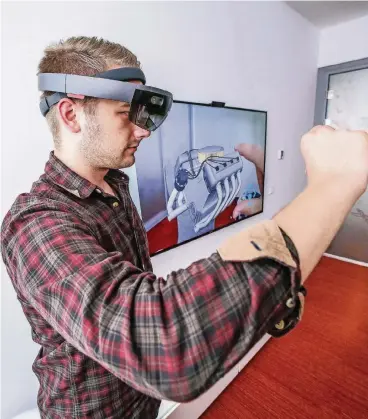  ??  ?? Test für ein System der Zukunft: Ein Mitarbeite­r der IT-Abteilung trägt eine elektronis­che 3-D-Brille. Auf dem Bildschirm hinter ihm können alle Anwesenden die Zeichnung einer Maschine sehen, die er auch sieht.