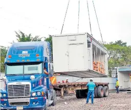  ??  ?? MONTAJE. Uno de los contenedor­es fue descargado ayer en el plantel anexo al Hospital del Tórax en Tegucigalp­a.