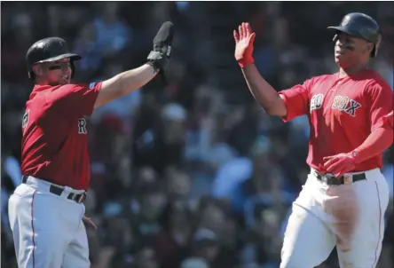  ?? CHARLES KRUPA - THE ASSOCIATED PRESS ?? Boston Red Sox’s Christian Vazquez, left, and Rafael Devers high-five after scoring on an Xander Bogaerts two RBI single during the second inning of a baseball game against the San Francisco Giants at Fenway Park in Boston, Thursday, Sept. 19, 2019.