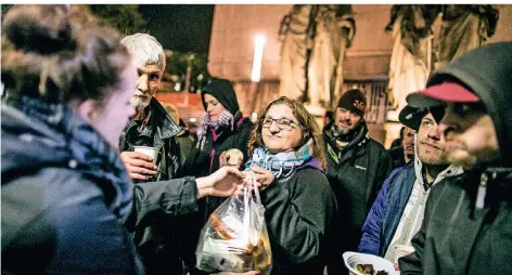  ?? FOTO: ANNE ORTHEN ?? Der „Gutenachtb­us“von fiftyfifty: Eine obdachlose Frau bekommt einen Beutel Lebensmitt­el gereicht.