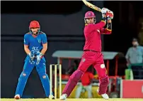  ?? AFP ?? Marlon Samuels (right) of West Indies plays a shot during the tie against Afghanista­n on Friday night. —