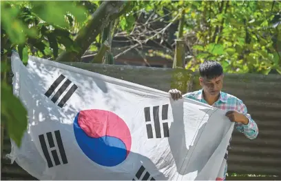  ?? Picture: AFP ?? MASSIVE FAN. Bangladesh­i chemist Abu Kowsir, who is a South Korea football fan, puts up a 3.5km long flag of South Korea from his home to a neighbouri­ng village.