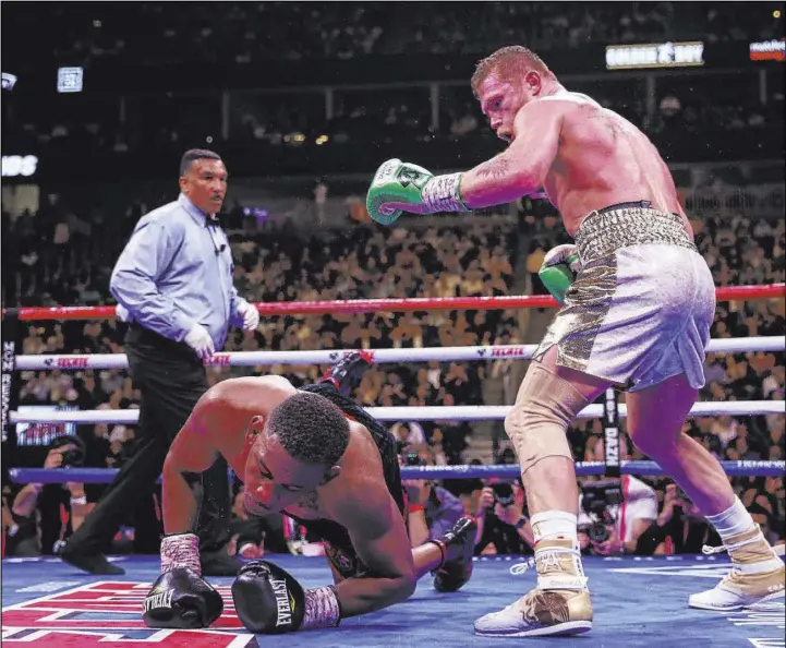  ?? Erik Verduzco Las Vegas Review-Journal @Erik_Verduzco ?? Daniel Jacobs slips to the mat in front of Saul “Canelo” Alvarez during the 12th round Saturday. “I have to go back to look at the tapes to see exactly what the judges thought,” Jacobs said. “… I tip my hat to (Alvarez). I gave my all out there.”