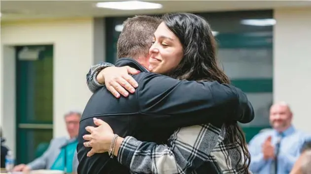  ?? PITTSBURGH POST-GAZETTE ?? Trafford Middle School special education teacher Alexis Simon, right, hugs co-teacher Michael Cleland during a school board meeting Feb. 6 in southweste­rn Pennsylvan­ia. Cleland, among others, was key in saving Simon’s life.