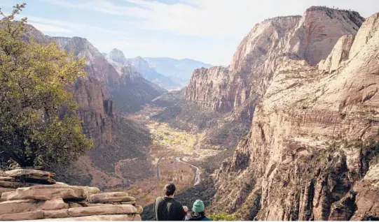  ?? NIKKI BOLIAUX/THE NEW YORK TIMES PHOTOS ?? Hikers take in the view Nov. 23 from the summit of the Angels Landing trail in Zion National Park in Utah, where the number of visitors has surged.