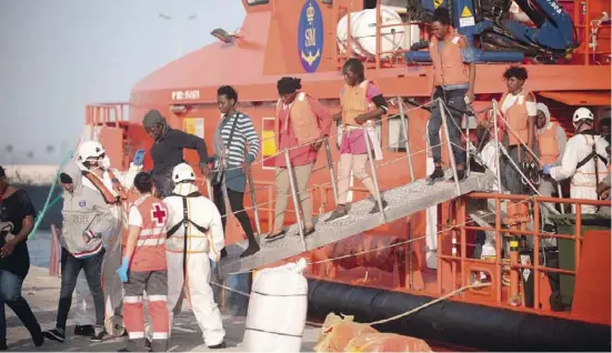  ?? Foto: Jesús Mérida, dpa ?? Immigrante­n gingen am Samstag in Málaga von Bord eines Rettungssc­hiffs.