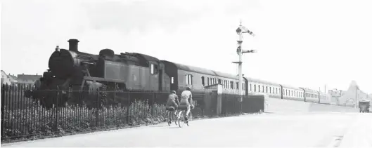  ?? S Rickard/J & J Collection ?? The ex- Barry Railway somersault signal is off as the doyen of the BR Standard ‘3MT’ 2-6-2Ts, No 82000, heads away from Barry Island with the 11.30am stopping passenger to Treherbert, target TC, on Sunday, 16 May 1954. In the background is the scenic railway, which was the star attraction at the funfair. The two cyclists and the milk float epitomise the sparse road traffic of the day. This particular locomotive was new to Tyseley in April 1952 but appeared in South Wales in the four-week period to 8 August 1953, at Barry, and became a Treherbert asset about two months later.