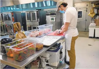  ?? KIM HAIRSTON/BALTIMORE SUN ?? Collin Morstein, owner of Scratch Made, a prepared meal delivery service, breaks down a chicken for coq au vin. His company operates out of a shared kitchen in Govans. The birds are from Rettland Farm in Gettysburg, Pennsylvan­ia.