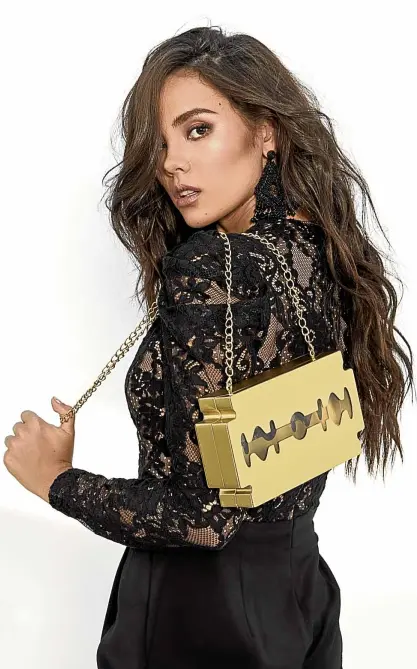  ??  ?? Lace jumpsuit by Michael Kors; “Blade” clutch bag in matte brushed brass finish with clear plexiglass by Doro Barandino