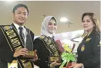  ?? MARIYAMA DINA/JAWA POS ?? DIBERI MANDAT: Dari kiri, Ajiono dan Tessa Rachmavian­i, mendapat karangan bunga dari Arie Soeripan Putri.