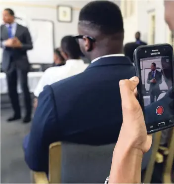  ?? RICARDO MAKYN/MULTIMEDIA PHOTO EDITOR ?? A sixth-form student of Jamaica College records on his cell phone Prime Minister Andrew Holness speaking with upper-school students the institutio­n's Old Hope Road premises on February 15.