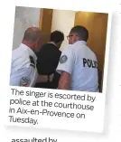  ??  ?? The singer is escorted by police at the courthouse in Aix-en-Provence on Tuesday.